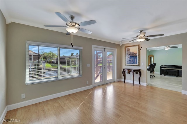 unfurnished room featuring french doors, light wood finished floors, and crown molding