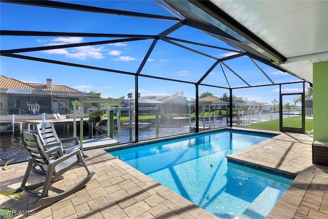 outdoor pool featuring glass enclosure, a dock, a water view, and boat lift