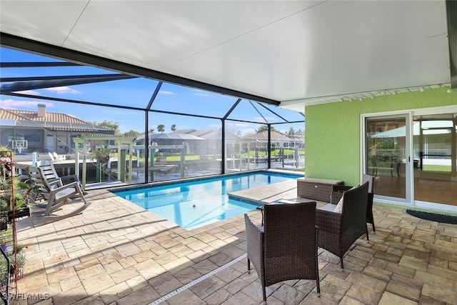 outdoor pool with glass enclosure, a residential view, and a patio