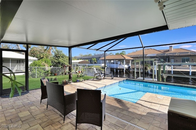 view of swimming pool with boat lift, a water view, fence, a yard, and a boat dock