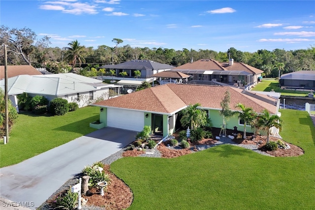 exterior space with driveway, a front lawn, an attached garage, and a residential view