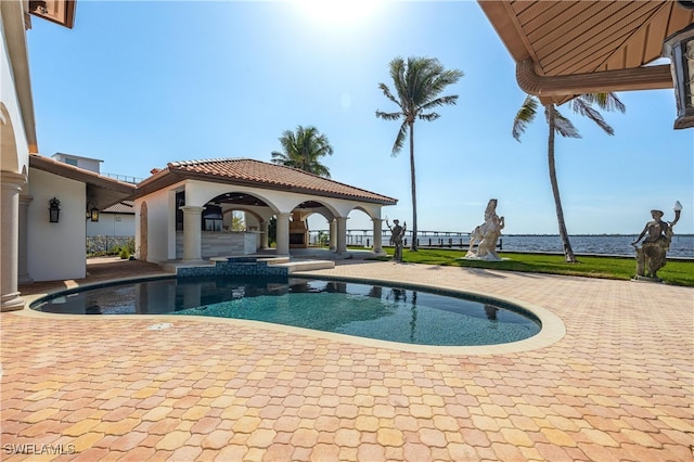 view of pool featuring a water view and a patio area