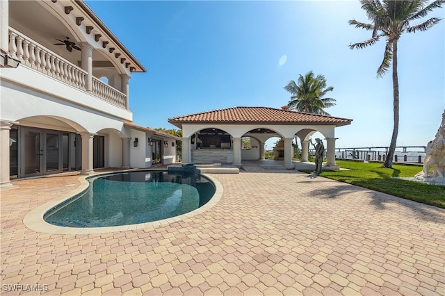 view of pool with a patio, a lawn, and ceiling fan