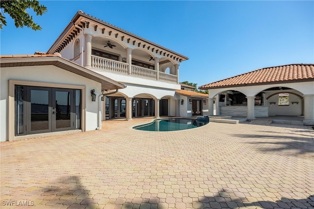 rear view of house with a balcony, french doors, a patio area, and ceiling fan