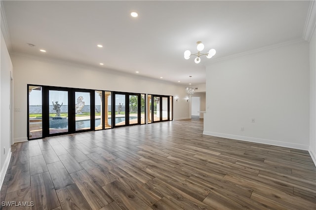 unfurnished living room with an inviting chandelier, ornamental molding, french doors, and dark hardwood / wood-style flooring