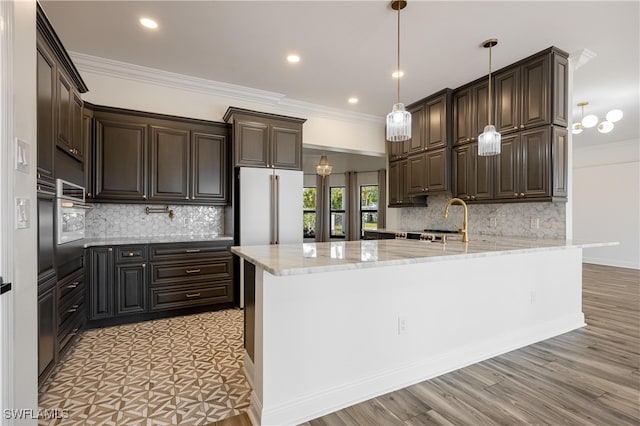 kitchen with ornamental molding, dark brown cabinets, kitchen peninsula, and decorative light fixtures