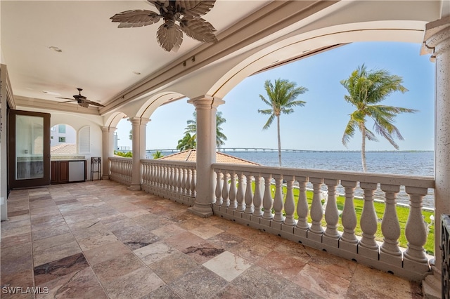 view of patio featuring a water view and ceiling fan