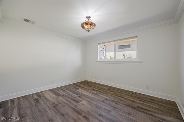 spare room with ornamental molding and dark hardwood / wood-style flooring