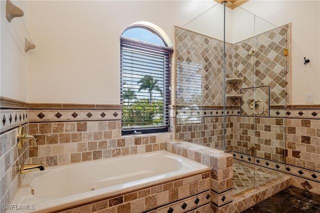 bathroom featuring shower with separate bathtub