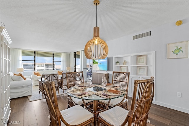 dining area with a textured ceiling and dark hardwood / wood-style flooring