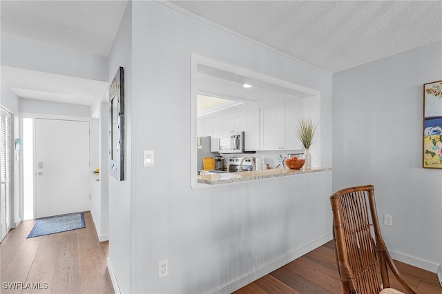 hall featuring a textured ceiling and light wood-type flooring