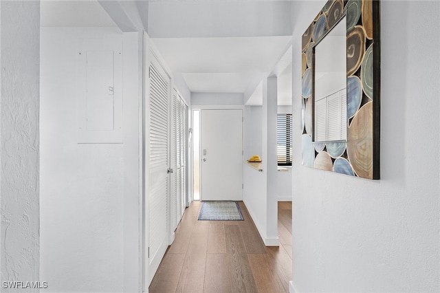 hallway with wood-type flooring and electric panel