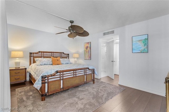 bedroom featuring ceiling fan, dark hardwood / wood-style flooring, and a textured ceiling