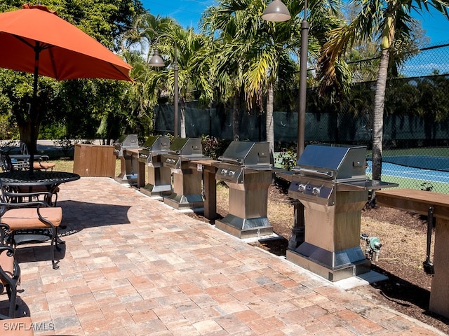 view of patio / terrace with a grill and tennis court