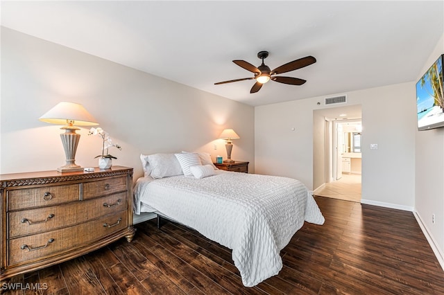 bedroom featuring ceiling fan, connected bathroom, and dark wood-type flooring