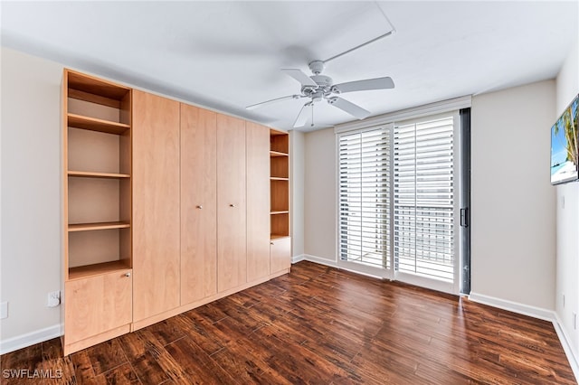 unfurnished bedroom with ceiling fan and dark wood-type flooring