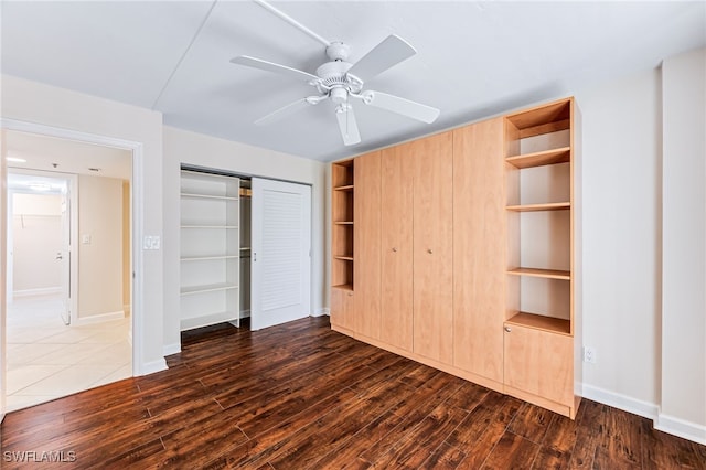 unfurnished bedroom featuring ceiling fan, dark hardwood / wood-style flooring, and a closet