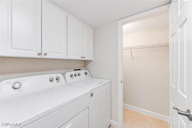 laundry area with cabinets, light tile patterned floors, and independent washer and dryer