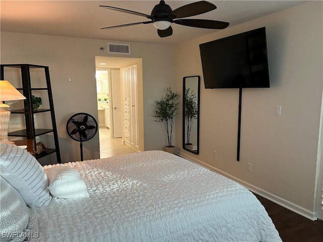 bedroom with ceiling fan, wood-type flooring, and ensuite bath