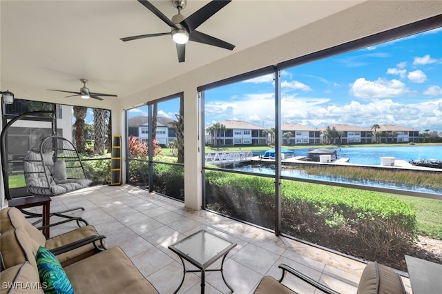 sunroom with a water view and ceiling fan