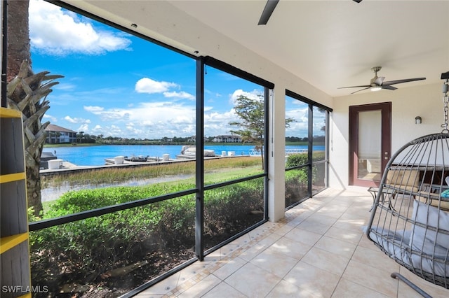 sunroom featuring a water view and ceiling fan