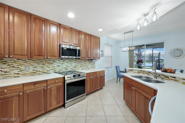 kitchen with decorative backsplash, appliances with stainless steel finishes, light tile patterned flooring, sink, and decorative light fixtures