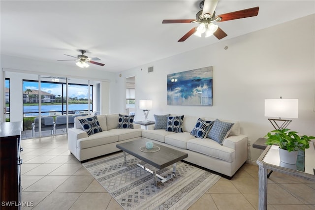 tiled living room featuring a water view and ceiling fan