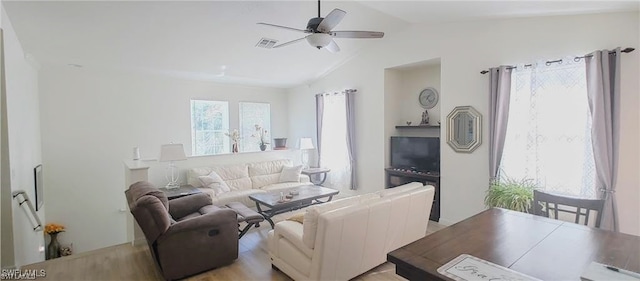 living room with light hardwood / wood-style flooring, ceiling fan, and vaulted ceiling