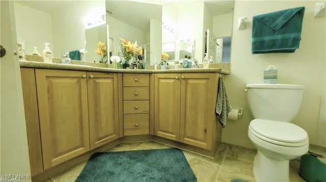 bathroom with toilet, vanity, and tile patterned flooring