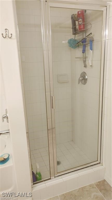 bathroom featuring tile patterned floors and a shower with shower door