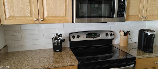 details with light brown cabinetry, black range with electric stovetop, light stone countertops, and backsplash