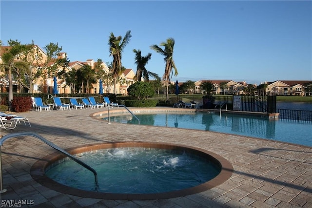 view of pool with a hot tub and a patio