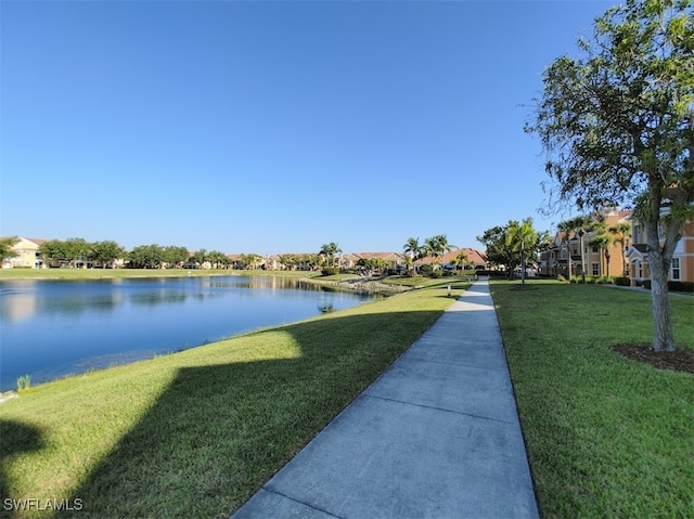 surrounding community with a water view and a yard