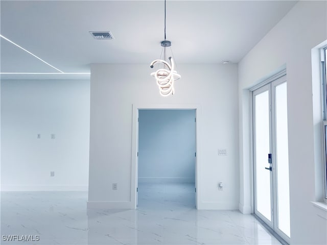 unfurnished room featuring an inviting chandelier