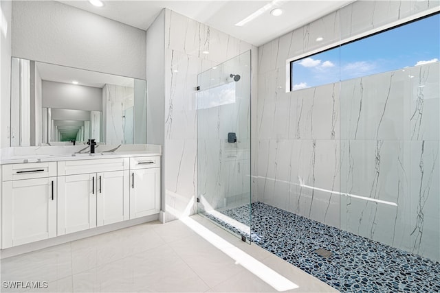 bathroom featuring vanity, a tile shower, and tile patterned floors