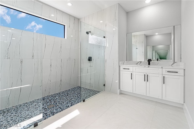 bathroom with vanity and a tile shower