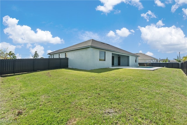 back of house with a patio area and a lawn