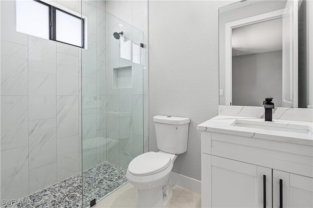 bathroom featuring toilet, an enclosed shower, vanity, and tile patterned flooring