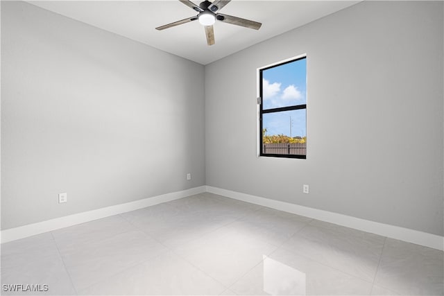 tiled empty room featuring ceiling fan