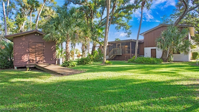 view of yard with a storage shed and a sunroom