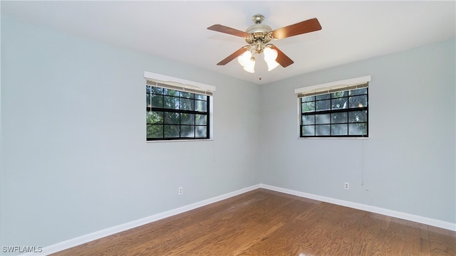 spare room featuring a wealth of natural light, hardwood / wood-style flooring, and ceiling fan