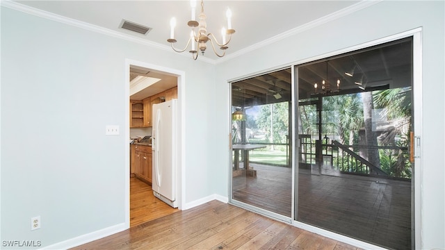 doorway to outside with light hardwood / wood-style floors, a chandelier, and crown molding