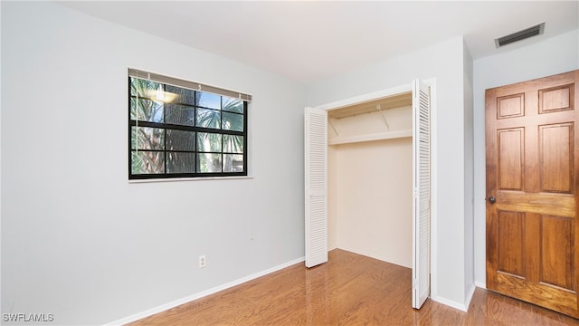 unfurnished bedroom featuring light hardwood / wood-style flooring and a closet