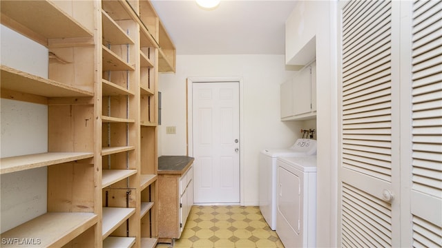 clothes washing area with cabinets and washing machine and dryer