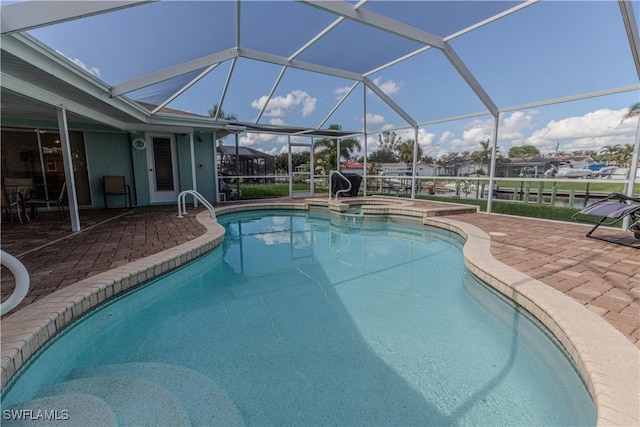 view of swimming pool featuring an in ground hot tub, glass enclosure, and a patio