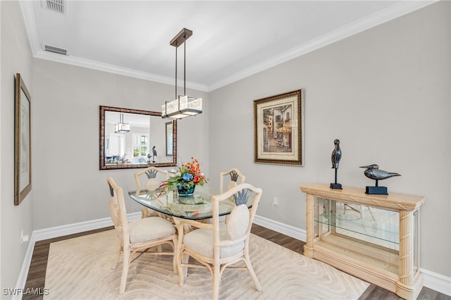 dining area with crown molding and wood-type flooring