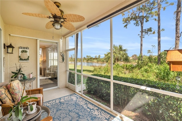 sunroom with a water view and ceiling fan