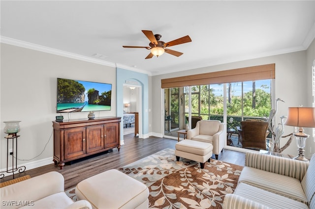 living room with dark wood-type flooring, ceiling fan, and crown molding