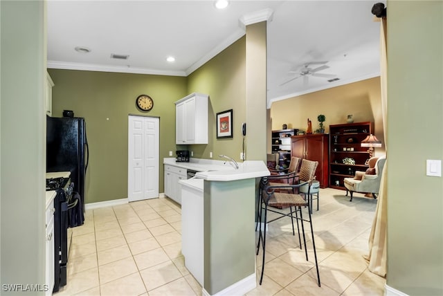 kitchen with ornamental molding, white cabinetry, black range with gas stovetop, a breakfast bar, and kitchen peninsula