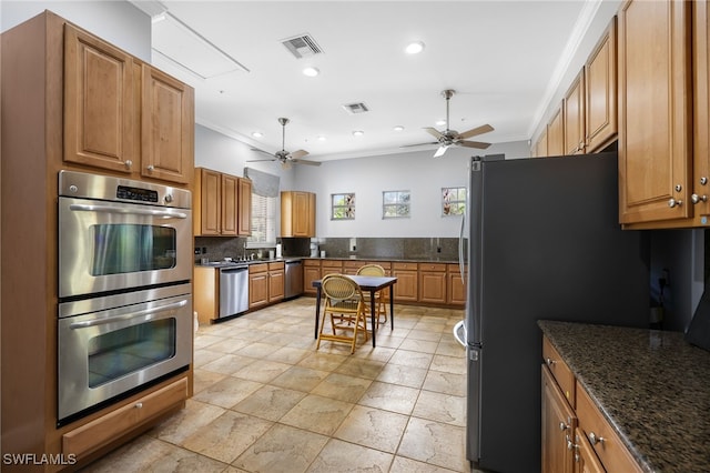 kitchen featuring dark stone countertops, decorative backsplash, ornamental molding, and stainless steel appliances